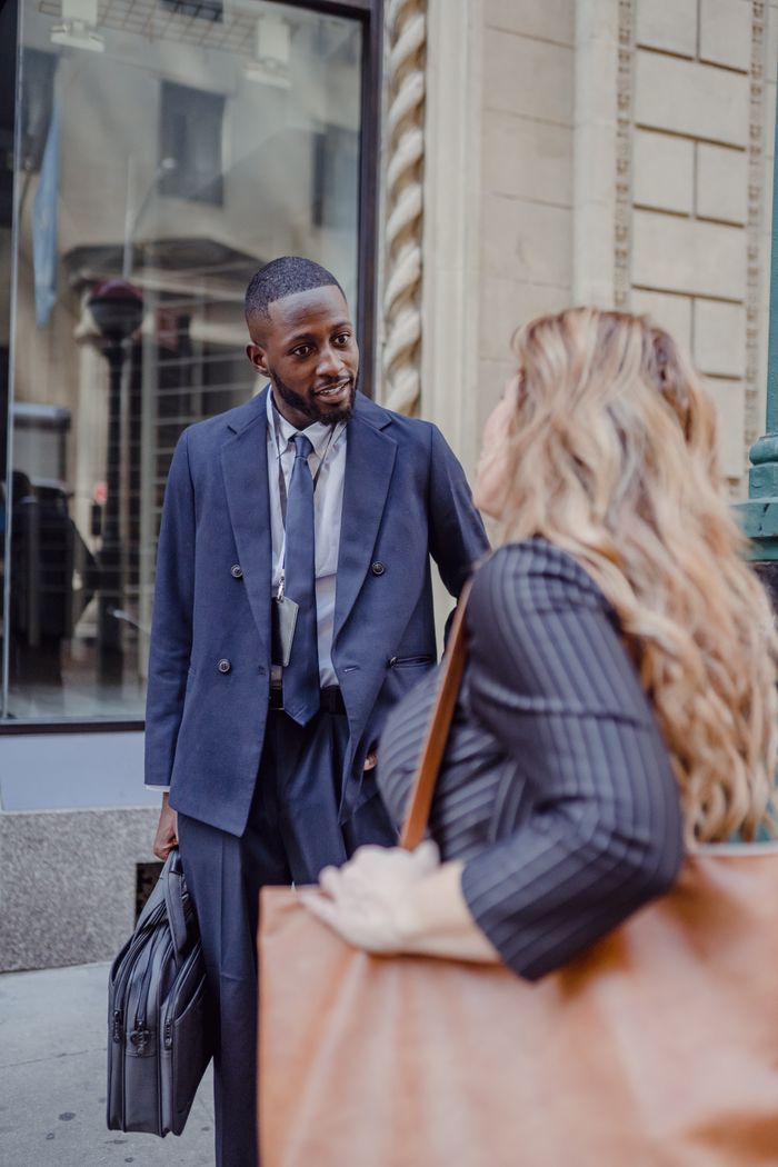 product-02 Two business professionals having a conversation on a busy city street, exchanging ideas.