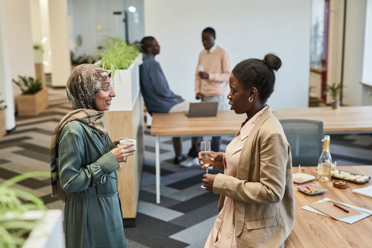 home-hero-img Group of diverse professionals networking in a modern office setting.